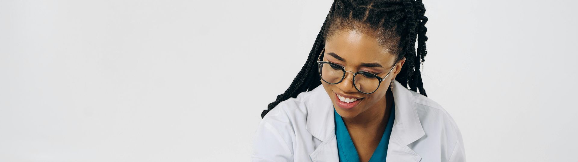 A female doctor sitting at a desk with a tablet and pen